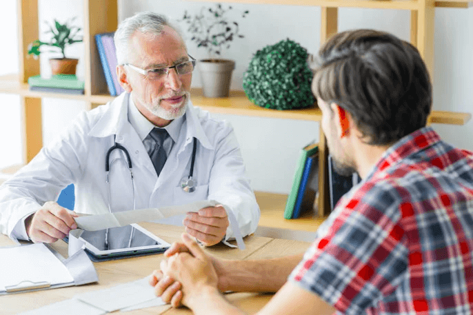 Médecin interagissant avec un patient dans un cadre médical professionnel.